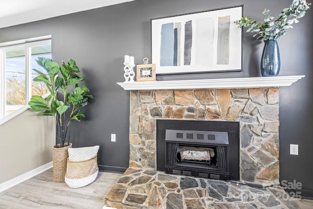 interior details featuring wood-type flooring and a stone fireplace