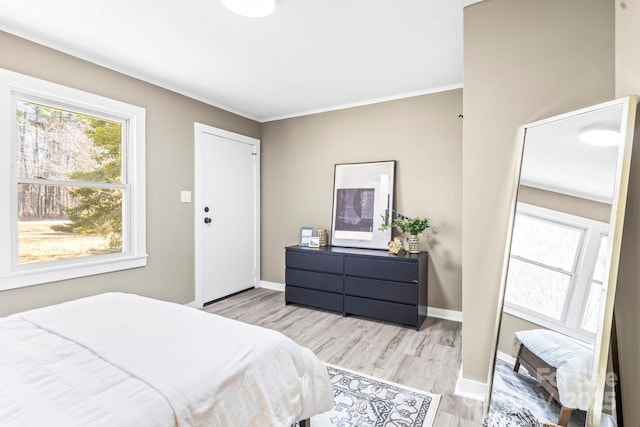 bedroom with crown molding and light hardwood / wood-style flooring