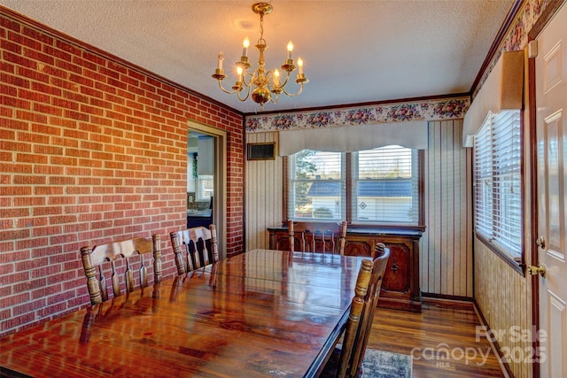 dining space featuring a textured ceiling, dark hardwood / wood-style floors, crown molding, and a notable chandelier