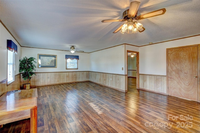 unfurnished living room featuring dark hardwood / wood-style flooring, ceiling fan, and crown molding