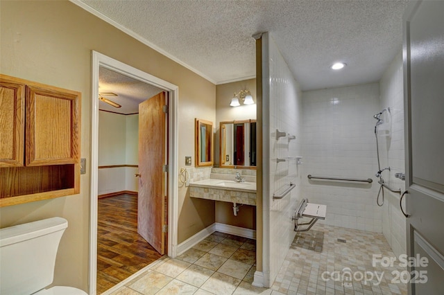 bathroom featuring tile patterned flooring, ceiling fan, toilet, ornamental molding, and a tile shower