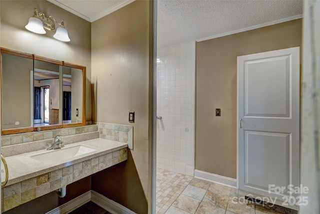 bathroom featuring a shower, sink, crown molding, and a textured ceiling