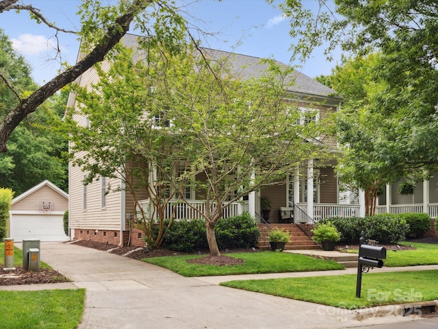 view of front of home with a front lawn, an outdoor structure, covered porch, and a garage