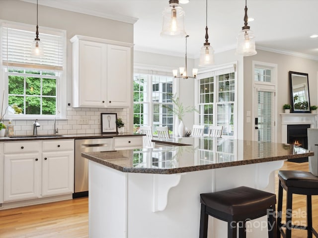 kitchen featuring white cabinetry, stainless steel dishwasher, tasteful backsplash, and sink