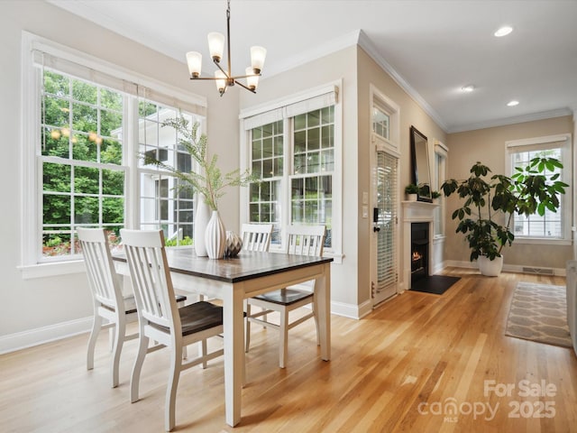 dining room featuring an inviting chandelier, crown molding, and light hardwood / wood-style floors