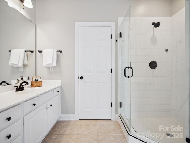 bathroom with a shower with shower door, vanity, and tile patterned flooring