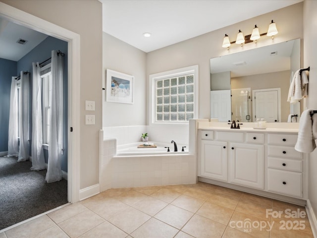 bathroom featuring tile patterned floors, tiled tub, and vanity