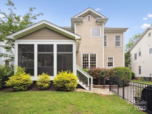 back of house with a sunroom and a lawn