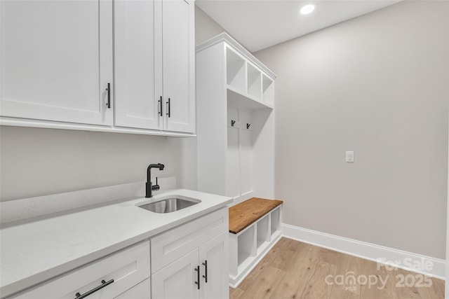 mudroom with sink and light hardwood / wood-style flooring