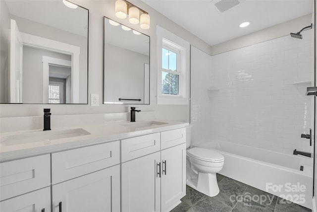 full bathroom featuring toilet, vanity, and tiled shower / bath combo