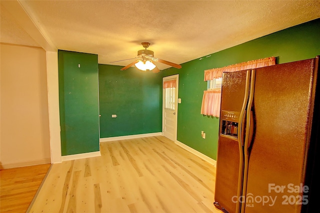 kitchen featuring a textured ceiling, ceiling fan, black fridge with ice dispenser, and wood-type flooring