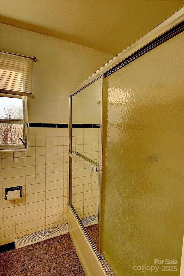 bathroom featuring combined bath / shower with glass door and tile patterned floors