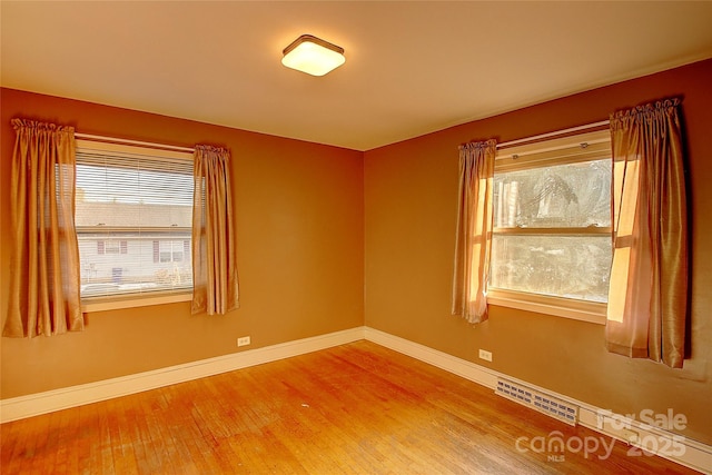 unfurnished room with hardwood / wood-style flooring