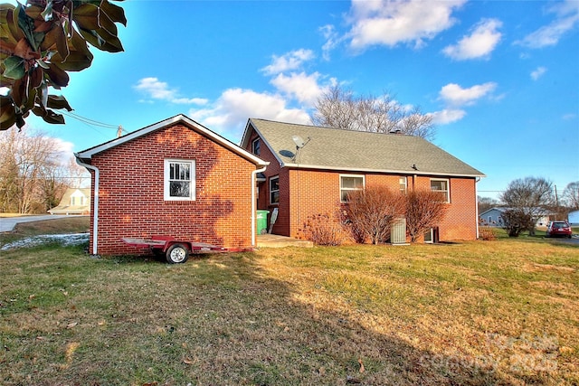 back of house with cooling unit and a yard