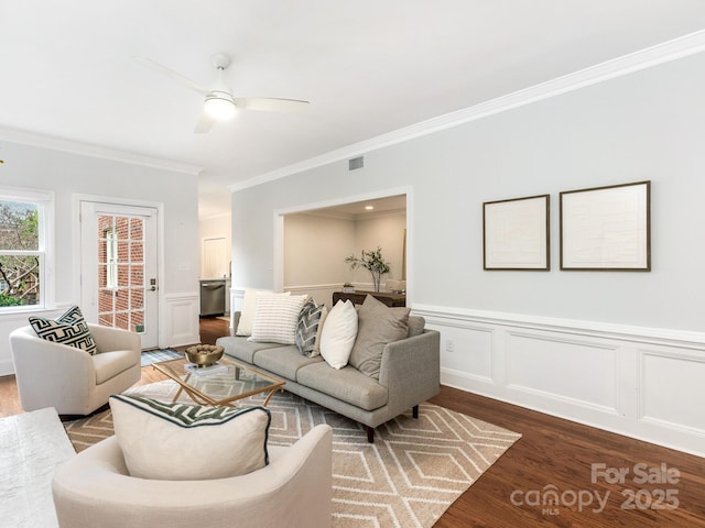 living room with hardwood / wood-style flooring, ceiling fan, and ornamental molding