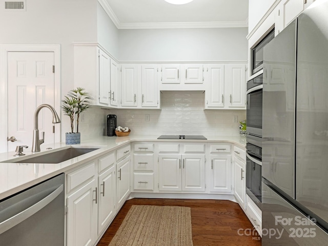 kitchen featuring tasteful backsplash, white cabinetry, appliances with stainless steel finishes, and sink