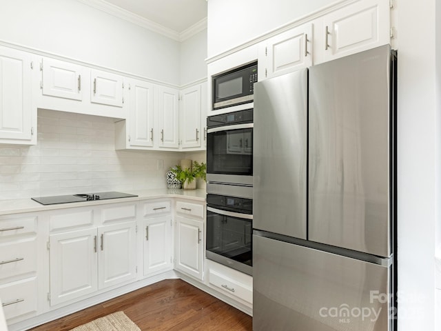 kitchen featuring built in microwave, white cabinetry, stainless steel fridge, ornamental molding, and black electric cooktop