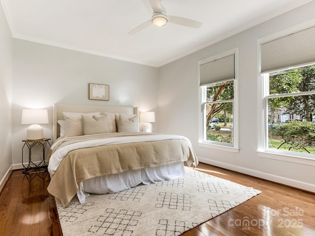 bedroom featuring hardwood / wood-style flooring, ceiling fan, and ornamental molding