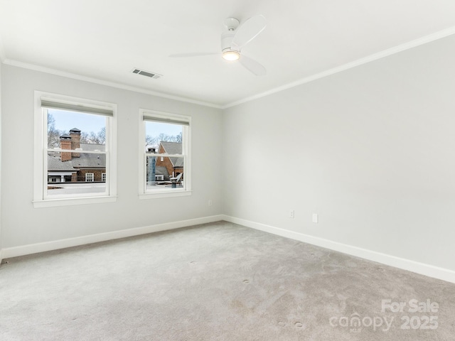 empty room featuring ornamental molding, carpet flooring, and ceiling fan