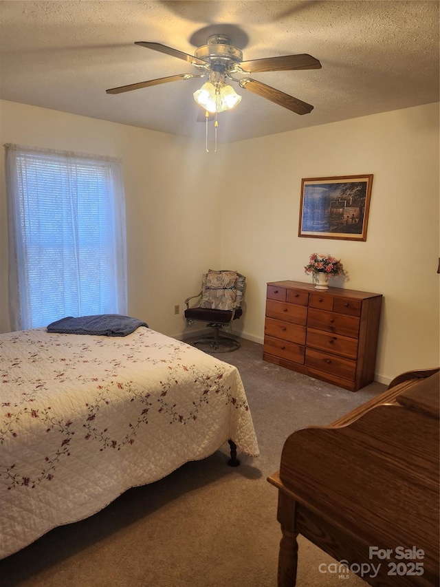 bedroom with a textured ceiling, ceiling fan, and carpet