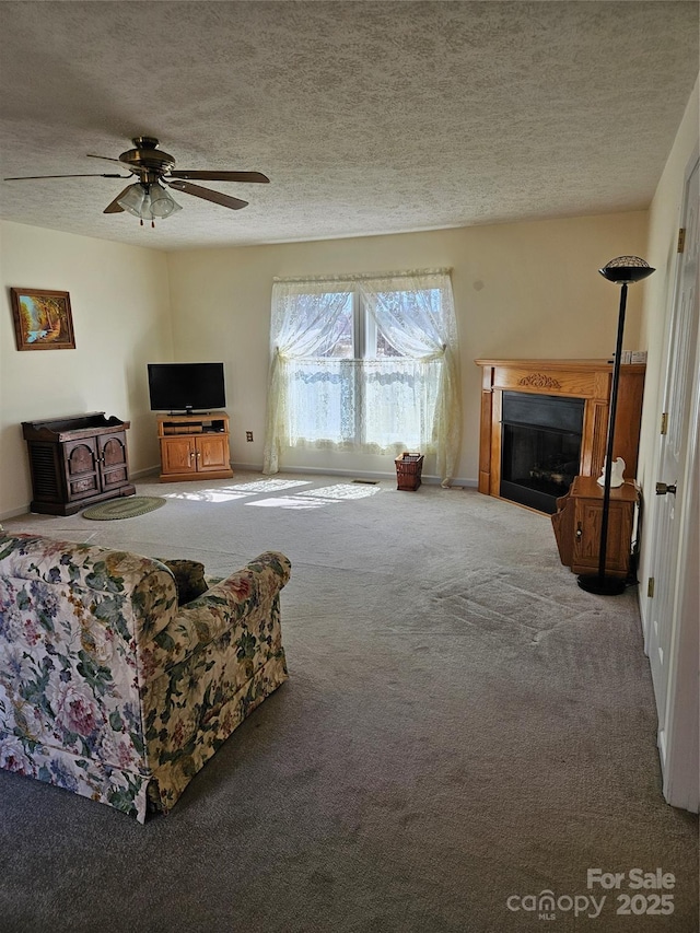 living room with carpet, a fireplace, a textured ceiling, and ceiling fan