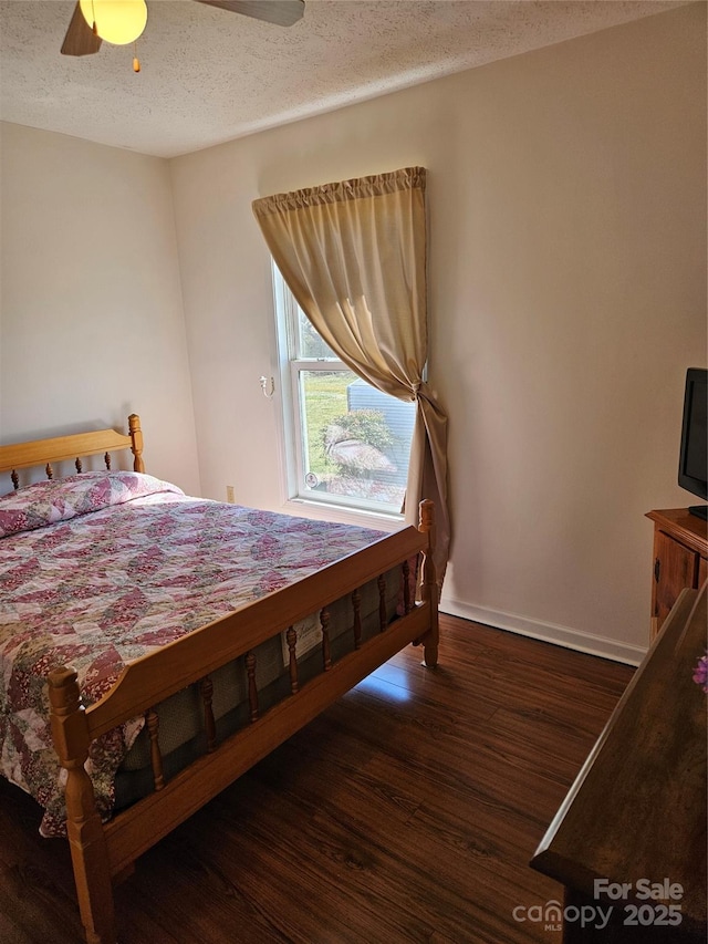 bedroom with ceiling fan, a textured ceiling, baseboards, and wood finished floors