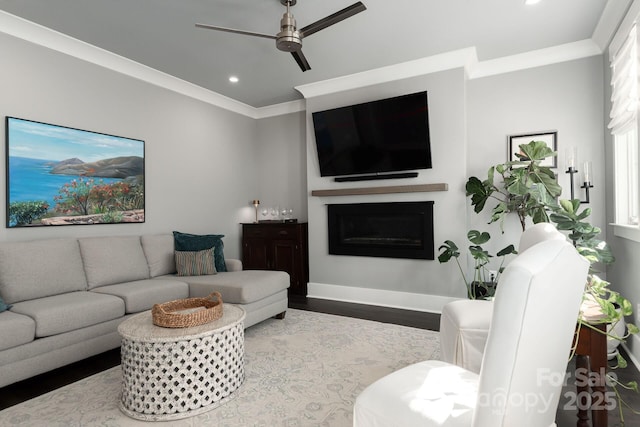 living room with ornamental molding, ceiling fan, and light wood-type flooring