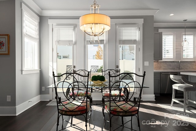 dining room featuring dark wood-type flooring, a chandelier, and sink