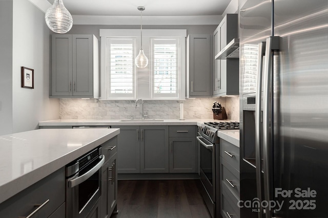 kitchen featuring gray cabinets, appliances with stainless steel finishes, decorative backsplash, sink, and decorative light fixtures