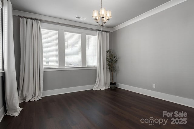 unfurnished room with an inviting chandelier, crown molding, and dark wood-type flooring