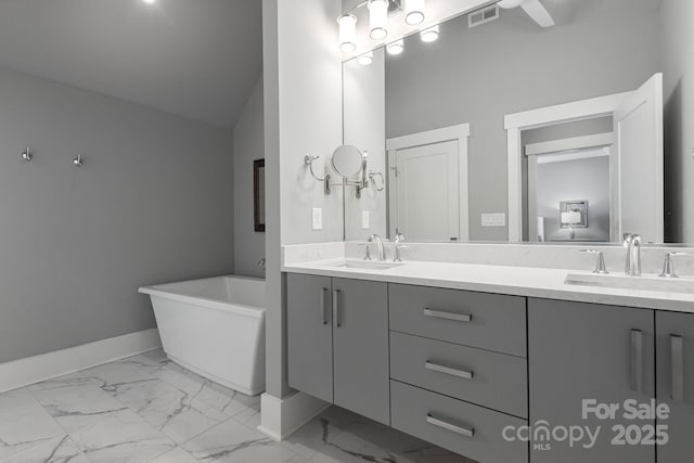 bathroom featuring lofted ceiling, a bath, and vanity