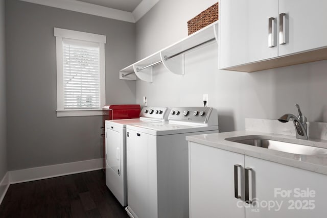 washroom with cabinets, ornamental molding, dark wood-type flooring, sink, and washing machine and clothes dryer