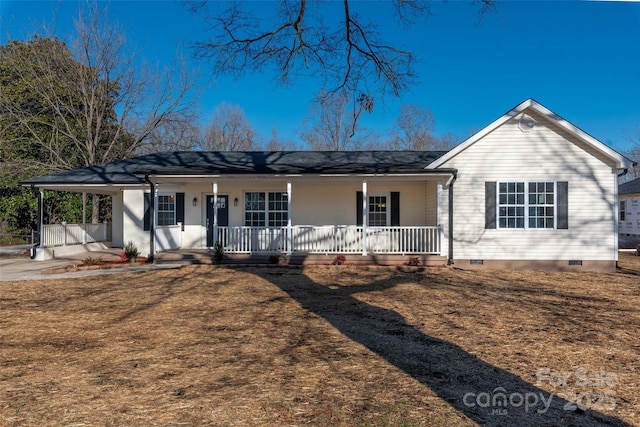 ranch-style home with covered porch, a carport, and a front lawn