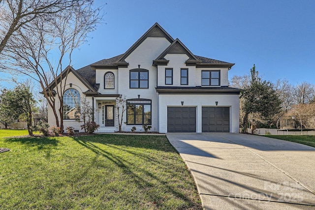 french country style house featuring a front lawn and a garage