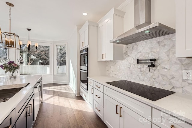 kitchen featuring backsplash, black stovetop, white cabinets, and wall chimney range hood