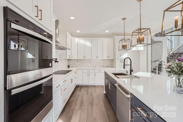 kitchen with white cabinets, decorative light fixtures, backsplash, and stainless steel appliances