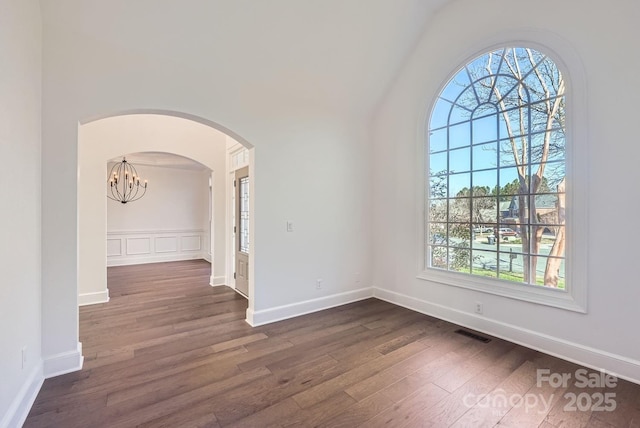 unfurnished room featuring dark wood-type flooring and a chandelier