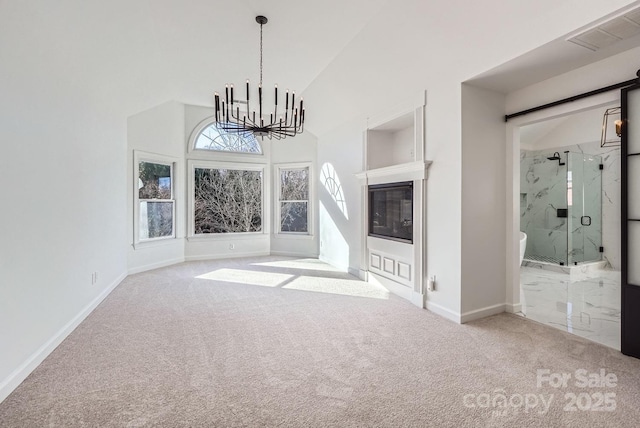 unfurnished living room with carpet floors, high vaulted ceiling, and an inviting chandelier