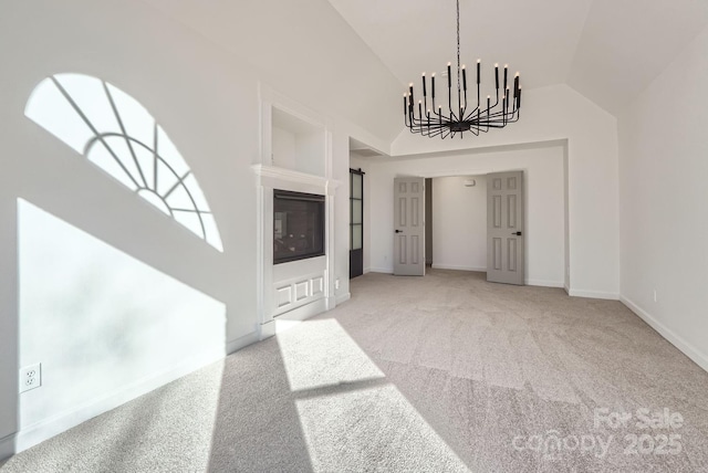 unfurnished living room with lofted ceiling, carpet floors, and a chandelier