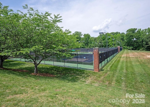 view of sport court with a lawn