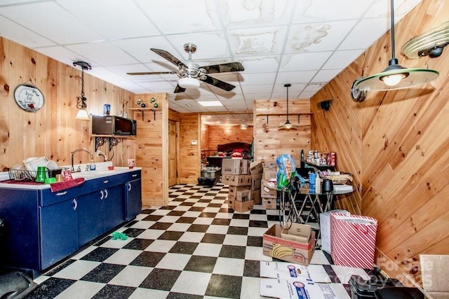 kitchen featuring wood walls and a drop ceiling