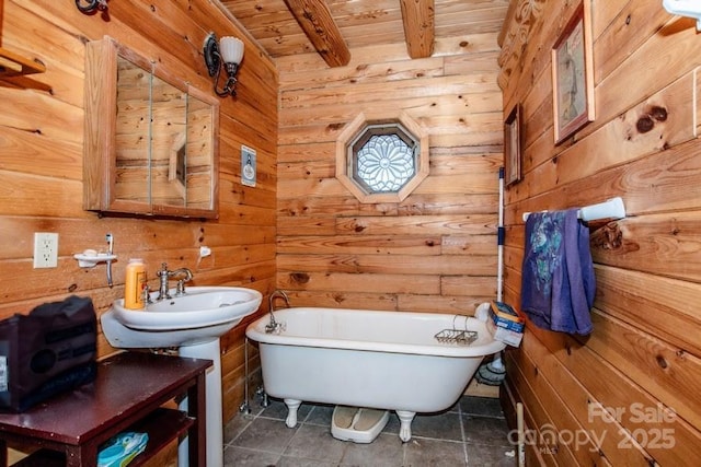 bathroom with a bath, wooden ceiling, beam ceiling, and wood walls