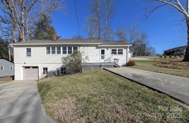 view of front of property with a front yard, a garage, and a deck