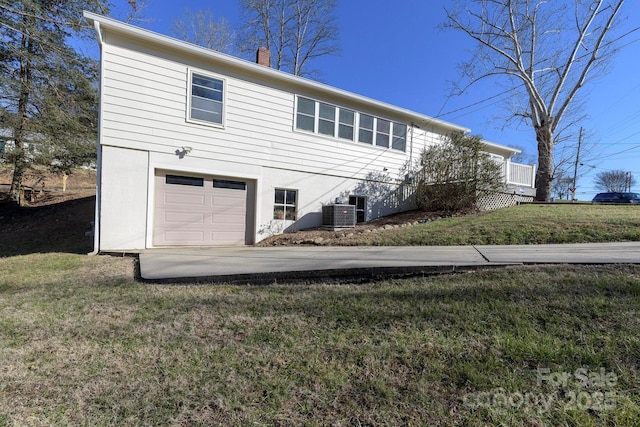 view of front of house featuring central AC, a front yard, and a garage