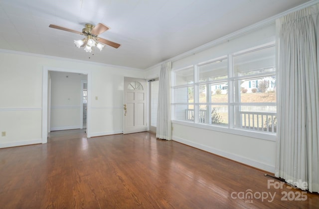 empty room with ceiling fan, dark hardwood / wood-style flooring, and ornamental molding