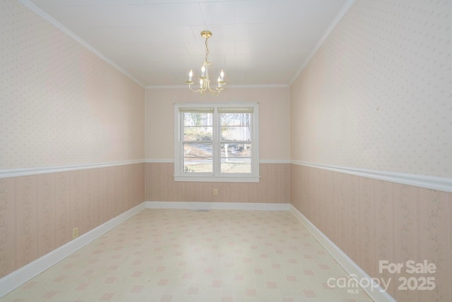 spare room featuring a chandelier and crown molding