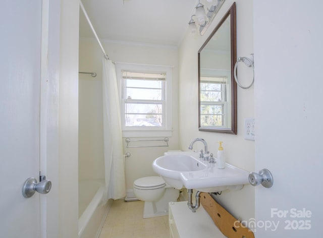 bathroom featuring ornamental molding, shower / bath combo with shower curtain, and toilet