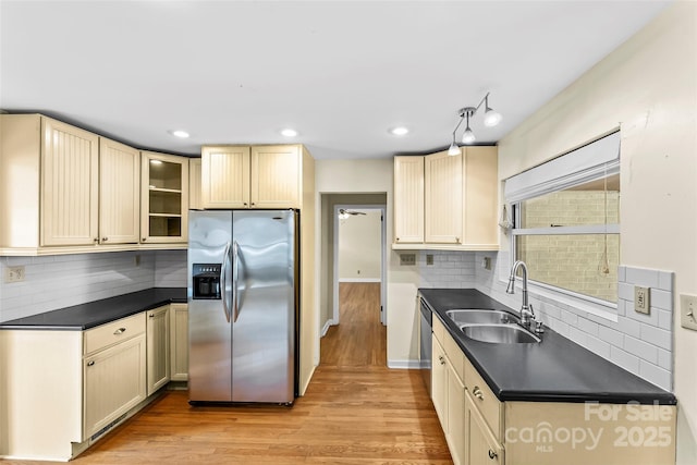 kitchen with appliances with stainless steel finishes, ceiling fan, sink, light hardwood / wood-style flooring, and backsplash