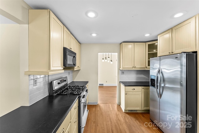 kitchen featuring decorative backsplash, light hardwood / wood-style floors, and appliances with stainless steel finishes