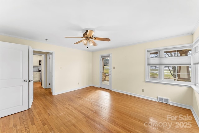 empty room with light wood-type flooring, ceiling fan, and crown molding